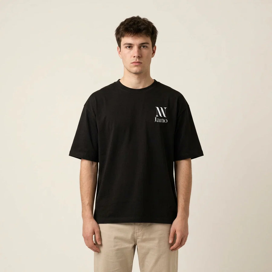 Model wearing the black NEW JANO Essential Tee with the small white chest logo
